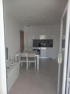 a kitchen with white cabinets and a table and chairs at Casa Cabeça in Macedo de Cavaleiros