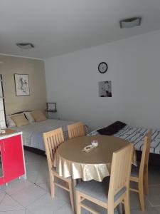 a bedroom with a bed and a table and chairs at Apartman Cvitan in Zaton