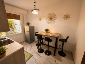 a kitchen with a table with stools and a refrigerator at Sa Domo Bonaria - Intero appartamento in Osilo +6 photos
