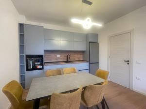 a kitchen and dining room with a table and chairs at Leni Apartment in Patza-Kuqani