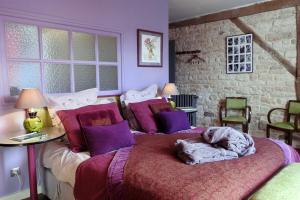 a bedroom with two beds with purple pillows at Le Piano in Biesles