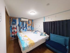 ein Schlafzimmer mit einem Bett und einem blauen Stuhl in der Unterkunft Yui HOSTEL in Tokio