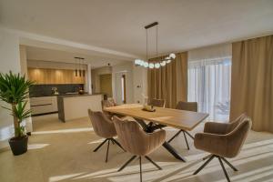 a dining room and kitchen with a wooden table and chairs at Villa de Pucci in Žminj