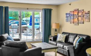 a living room with a leather couch and chairs at Put-in-Bay Poolview Condo #2 in Put-in-Bay