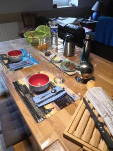 a wooden table with plates and bowls on top of it at Ti Bleunv-nevez in Moëlan-sur-Mer