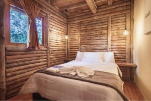 a bedroom with a bed in a log cabin at Olimpo Interior in Santa Elena
