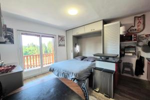 a bedroom with a bed and a balcony at Cozy apartment "WAPITI" at the foot of the slopes in Les Déserts