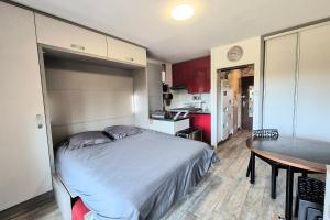 a small bedroom with a bed and a table at Cozy apartment "WAPITI" at the foot of the slopes in Les Déserts