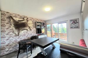 a living room with a table and a brick wall at Cozy apartment "WAPITI" at the foot of the slopes in Les Déserts