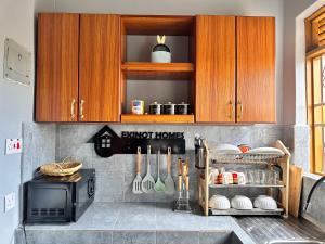 a kitchen with wooden cabinets and a stove at Ekinot homes in Lira