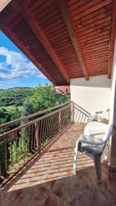 a porch with two chairs on a wooden deck at Hidden Haven Cottage Sarajevo in Lokve