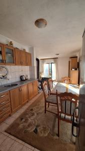 a kitchen with wooden cabinets and a table and chairs at Hidden Haven Cottage Sarajevo in Lokve