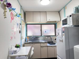 eine kleine Küche mit Kühlschrank und Tisch in der Unterkunft Yui HOSTEL in Tokio