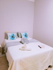 a bedroom with a white bed with towels on it at Bom Viver Pousada-Viçosa do Ceará -CE in Viçosa do Ceará