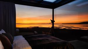 a view of a sunset from a room with a camera at Mystic Light Lodge in Búðardalur +29 photos