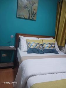 a bedroom with a bed with a blue wall at GusBek Condo Unit San Remo Oasis Cebu in Cebu City