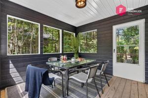 a screened in porch with a table and chairs at L'Azur de Portneuf - Chalet lumineux avec spa et véranda à Pont-Rouge - Resort près de Québec in Pont-Rouge