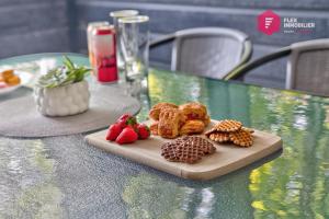 a plate of cookies and strawberries on a table at L'Azur de Portneuf - Chalet lumineux avec spa et véranda à Pont-Rouge - Resort près de Québec in Pont-Rouge