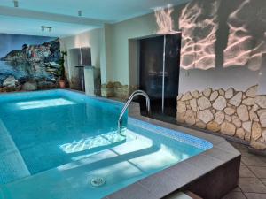 a bathroom with a large pool with a rock wall at Willa Roża Wiatrów in Karpacz
