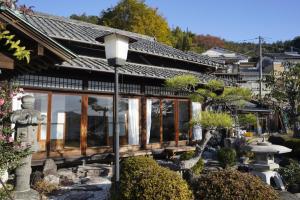 a house with a lot of windows and a street light at Guest House Toranjyo-lit in Tamano