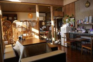 a living room with a table and a refrigerator at Guest House Toranjyo-lit in Tamano