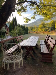 a wooden picnic table and a swing in a park at Rafting Centar Bato in Plužine