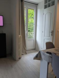a room with a door and a table and a window at Studio 4 personnes in Eaux-Bonnes
