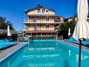 a hotel with a swimming pool in front of a building at Эллада in Chornomorsk
