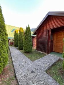 a garden with a path next to a house at Rafting Centar Bato in Plužine