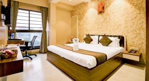 a bedroom with a bed and a desk in a room at Urban Cliff Hotel in Kolkata +26 photos
