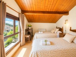 two beds in a room with a window at Duplex La Valle Ordesa-Ainsa in Laspuña
