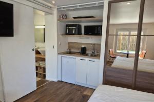 a bedroom with a bed and a kitchen with a sink at Lodge avec piscine chauffée privative et ou Studio avec son SPA, SAUNA HAMAMM privatifs in Cepoy