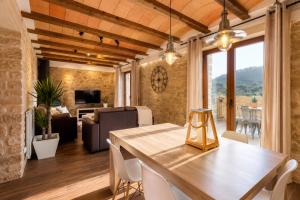 a dining room with a table and chairs and a living room at El Gresol - Naturaleza y Relax in Senant