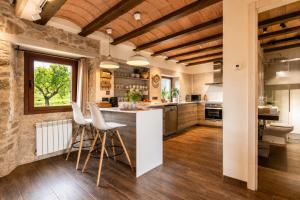 a kitchen with a counter and stools in a room at El Gresol - Naturaleza y Relax in Senant