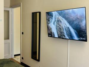 a flat screen tv hanging on a wall at Station -Mansarda in posizione strategica, vista panoramica, letto king size e clima in Ivrea