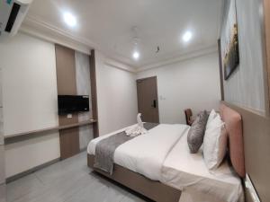 a bedroom with a bed and a flat screen tv at Hotel Emirest in Bhilad