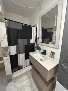 a bathroom with a black and white shower curtain and a sink at Vieques Good Vibe Guest House in Vieques +66 photos