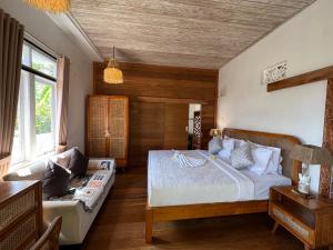 a bedroom with a bed and a couch at Kanda Homestay in Sidemen