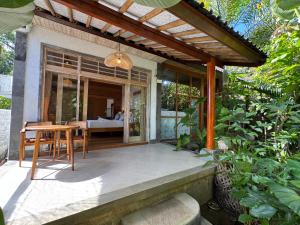 a patio with a table and a dining room at Kanda Homestay in Sidemen