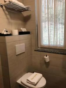 a bathroom with a white toilet and a window at Appart-Hotel Gwendy in Bour