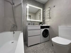 a bathroom with a washer and dryer in it at DeMar Apart Sun in Lviv