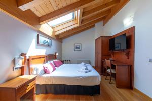 a bedroom with a bed and a desk and a television at Hotel Casa Azcona in Zizur Mayor +36 photos