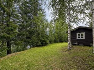 a cabin in the middle of a field with a tree at Turifoss Camping Cabin 2 in Svedjan