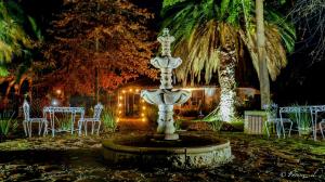 a fountain in the middle of a yard with tables and chairs at Hotel Boutique Raíces de Colchagua in Santa Cruz