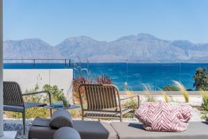 two chairs and a table with a view of the ocean at NOMIA Seaside Living in Agios Nikolaos