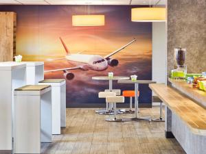 a restaurant with an airplane painting on the wall at ibis budget Marseille Aeroport Provence in Marignane