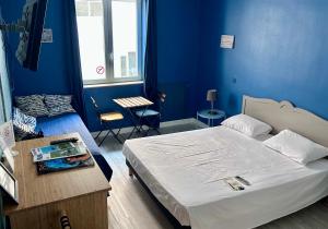 a bedroom with blue walls and a bed in a room at Hôtel Le Petit Baigneur in Palavas-les-Flots +100 photos