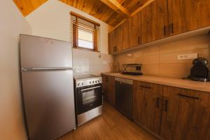 a kitchen with a stainless steel refrigerator and wooden cabinets at Durmitor Horizons in Žabljak