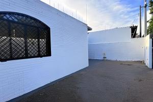 a white brick wall with a window on it at 2 Suítes com Ar e Cozinha Completa in Andradina