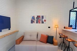 a living room with a couch and a tv at 2 Suítes com Ar e Cozinha Completa in Andradina